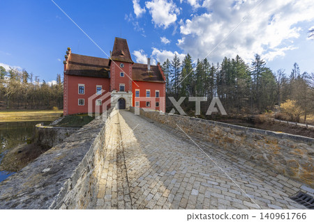 Cervena Lhota castle, historic red building over water in Czechia Cervena Lhota castle, historic red building over water in Czechia 140961766