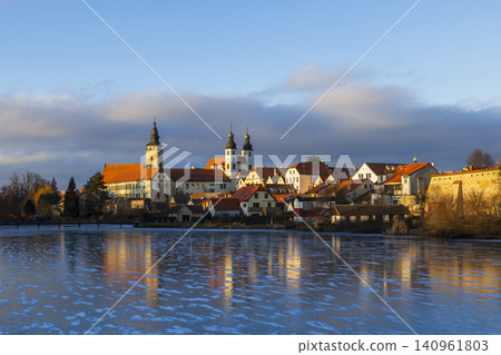 Telc historic town reflecting in frozen lake during sunset Telc historic town reflecting in frozen lake during sunset 140961803