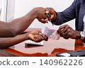 real estate agent and a client holding money and greeting each other in the office. 140962226