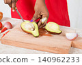 Hands of woman cutting avocados. 140962233
