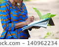 adult business woman examining the flowers while writing in a do 140962234
