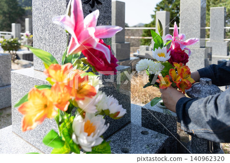 Image of arranging flowers for graves during the Obon festival. Image of arranging flowers for graves during the Obon festival. 140962320