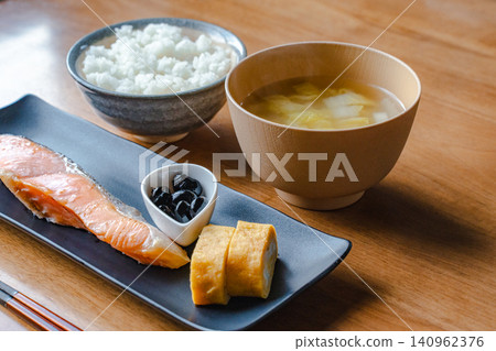 A close-up of a Japanese breakfast featuring rolled omelet, grilled salmon, rice, and miso soup. A close-up of a Japanese breakfast featuring rolled omelet, grilled salmon, rice, and miso soup. 140962376