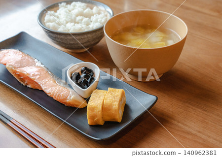 A traditional Japanese breakfast consisting of grilled salmon, rolled omelet, rice, and miso soup. A traditional Japanese breakfast consisting of grilled salmon, rolled omelet, rice, and miso soup. 140962381