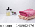 Towel, shampoo, conditioner, and soap arranged on a neutral background with space for text and branding elements. 140962476