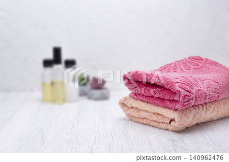 Towel, shampoo, conditioner, and soap arranged on a neutral background with space for text and branding elements. 140962476