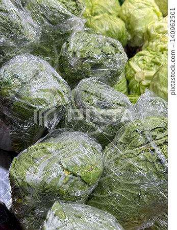 Plastic-wrapped cabbages bin Chinese cabbage in the store wrapped in plastic. Cabbage for sale vegetable market. Vegetables. Products at the market. Close-up of Chinese cabbage on a shelf in a store Plastic-wrapped cabbages bin Chinese cabbage in the store wrapped in plastic. Cabbage for sale vegetable market. Vegetables. Products at the market. Close-up of Chinese cabbage on a shelf in a store 140962501