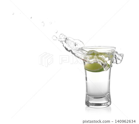 Splashing Mexican Tequila in shot glass with lime slice isolated on white Splashing Mexican Tequila in shot glass with lime slice isolated on white 140962634