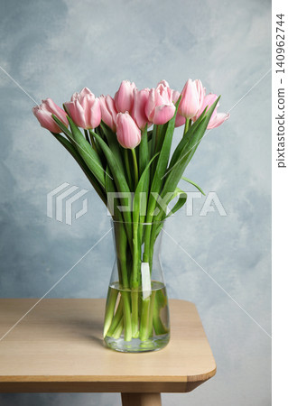 Beautiful pink spring tulips in vase on wooden table Beautiful pink spring tulips in vase on wooden table 140962744