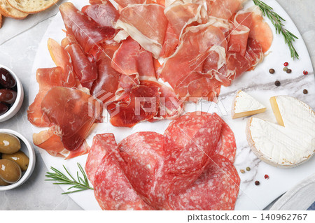 Tasty prosciutto served on light grey marble table, flat lay Tasty prosciutto served on light grey marble table, flat lay 140962767