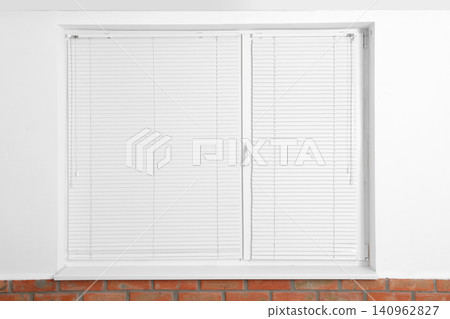 Modern window with closed blinds in room Modern window with closed blinds in room 140962827