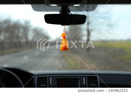 Air freshener hanging on rear view mirror in car Air freshener hanging on rear view mirror in car 140962835