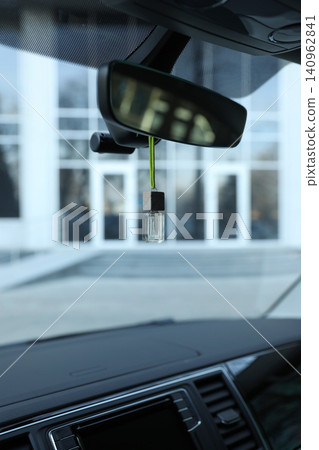 Air freshener hanging on rear view mirror in car Air freshener hanging on rear view mirror in car 140962841