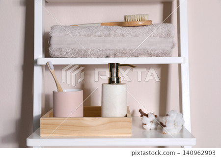 Shelving unit with toiletries near light wall indoors. Bathroom interior element Shelving unit with toiletries near light wall indoors. Bathroom interior element 140962903