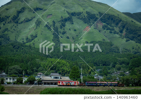 The One Piece train and the trolley train are coupled together as they run through the mountains of Minami Aso. 140963460