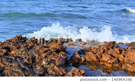 Waves crashing over rocky shoreline with sea spray Waves crashing over rocky shoreline with sea spray 140964198