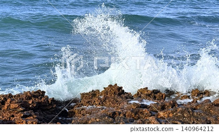 Waves crashing over rocky shoreline with spray Waves crashing over rocky shoreline with spray 140964212