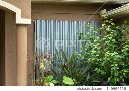 Hurricane shutters made from steel mounted for protection of house windows. Protective measures before natural disaster in Florida Hurricane shutters made from steel mounted for protection of house windows. Protective measures before natural disaster in Florida 140964516