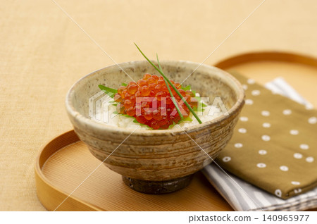 一碗盛在木碗裡的奢華白飯,上面鋪滿了鮭魚籽。 一碗盛在木碗裡的奢華白飯,上面鋪滿了鮭魚籽。 140965977