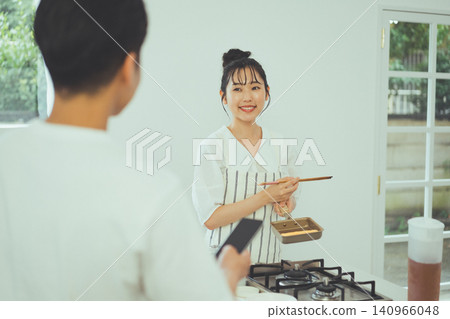 廚房裡一幅肖像畫,畫中一位身穿圍裙的女子,正溫柔地從一位男子的肩頭探出頭來微笑。 廚房裡一幅肖像畫,畫中一位身穿圍裙的女子,正溫柔地從一位男子的肩頭探出頭來微笑。 140966048
