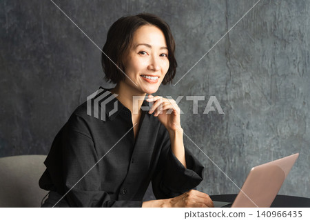 一位女士在桌旁使用筆記型電腦。 (生活照) 一位女士在桌旁使用筆記型電腦。 (生活照) 140966435