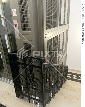 Vintage Industrial Elevator with Metal Mesh and Ornate Iron Railings - Historic Building Interior Vintage Industrial Elevator with Metal Mesh and Ornate Iron Railings - Historic Building Interior 140966514