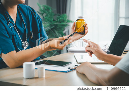 Doctor explaining prescription medication bottle to a patient during clinic visit, healthcare consultation, pharmacy, dosage advice, treatment, and patient education concept. Doctor explaining prescription medication bottle to a patient during clinic visit, healthcare consultation, pharmacy, dosage advice, treatment, and patient education concept. 140966621