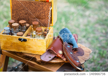 A spice bottle and a craft knife placed on a wooden mini stool. A spice bottle and a craft knife placed on a wooden mini stool. 140966736