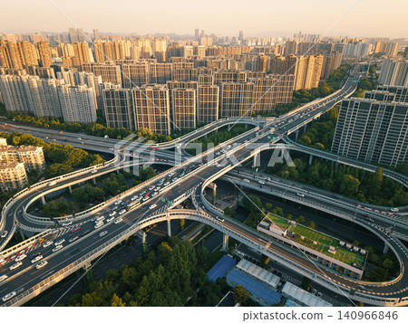 Aerial panoramic view captures complex elevated highway structure carrying moving vehicles through a modern urban landscape in China at dusk Aerial panoramic view captures complex elevated highway structure carrying moving vehicles through a modern urban landscape in China at dusk 140966846