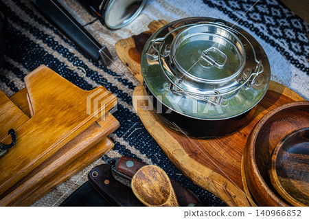 Stainless steel cooker and wooden plate set on a wooden plate. Stainless steel cooker and wooden plate set on a wooden plate. 140966852