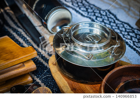 Stainless steel cookware and outdoor gear beautifully arranged at the campsite Stainless steel cookware and outdoor gear beautifully arranged at the campsite 140966853