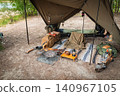 A complete set of stylish, masculine camping gear neatly arranged under the tent. 140967105