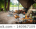 A cool campsite with a waterside location as the backdrop, featuring bottle racks and carefully selected gear. 140967109