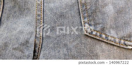 The texture of light blue denim jeans featuring pockets and contrast stitching. The texture of light blue denim jeans featuring pockets and contrast stitching. 140967222