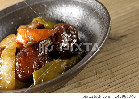 A single serving of sweet and sour pork with black vinegar, containing carrots, onions, bell peppers, and pork shoulder. A single serving of sweet and sour pork with black vinegar, containing carrots, onions, bell peppers, and pork shoulder. 140967346