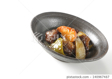 A single serving of sweet and sour pork with black vinegar, containing carrots, onions, bell peppers, and pork shoulder, photographed against a white background. A single serving of sweet and sour pork with black vinegar, containing carrots, onions, bell peppers, and pork shoulder, photographed against a white background. 140967487