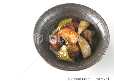 A single serving of sweet and sour pork with black vinegar, containing carrots, onions, bell peppers, and pork shoulder, photographed against a white background. A single serving of sweet and sour pork with black vinegar, containing carrots, onions, bell peppers, and pork shoulder, photographed against a white background. 140967518