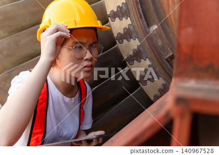 Young Asian engineer teen woman working service power plant turbine fan blade electrical generator Young Asian engineer teen woman working service power plant turbine fan blade electrical generator 140967528