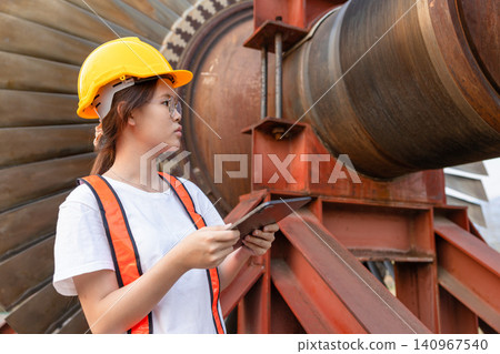 Young Asian engineer teen woman working service power plant turbine fan blade electrical generator Young Asian engineer teen woman working service power plant turbine fan blade electrical generator 140967540
