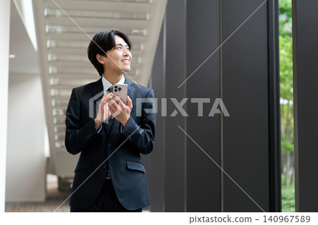 一位正在操作智慧型手機的亞洲商人 140967589