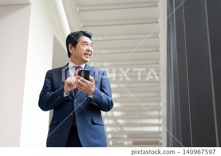 Asian businessman operating a smartphone Asian businessman operating a smartphone 140967597