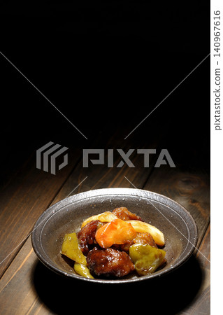 A single serving of sweet and sour pork with black vinegar, containing carrots, onions, bell peppers, and pork shoulder. A single serving of sweet and sour pork with black vinegar, containing carrots, onions, bell peppers, and pork shoulder. 140967616