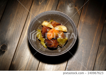 A single serving of sweet and sour pork with black vinegar, containing carrots, onions, bell peppers, and pork shoulder. A single serving of sweet and sour pork with black vinegar, containing carrots, onions, bell peppers, and pork shoulder. 140967623