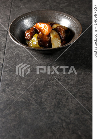 A single serving of sweet and sour pork with black vinegar, containing carrots, onions, bell peppers, and pork shoulder. A single serving of sweet and sour pork with black vinegar, containing carrots, onions, bell peppers, and pork shoulder. 140967657