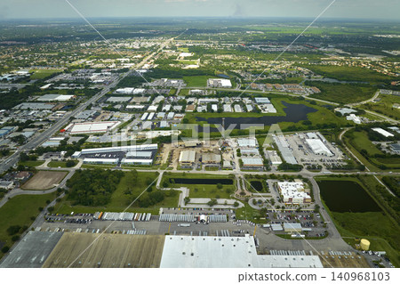 High angle view of big commercial shipping center with many freight trucks unloading and uploading goods for further distribution. Global economy concept High angle view of big commercial shipping center with many freight trucks unloading and uploading goods for further distribution. Global economy concept 140968103