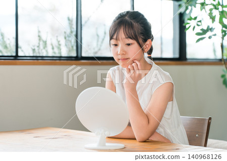 Elementary school and junior high school girls looking in the mirror (skin care, acne) Elementary school and junior high school girls looking in the mirror (skin care, acne) 140968126