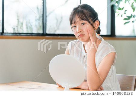 Looking in the mirror, elementary school and junior high school girls suffering from rough skin and acne Looking in the mirror, elementary school and junior high school girls suffering from rough skin and acne 140968128