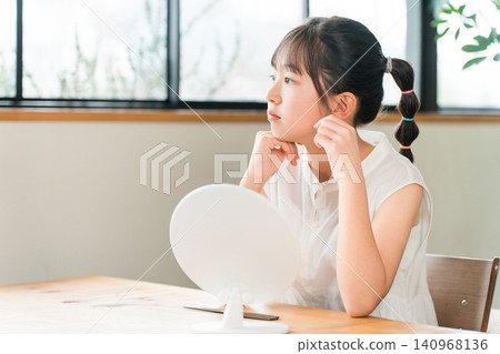 小學和國中女生在鏡子前露出不滿的表情 小學和國中女生在鏡子前露出不滿的表情 140968136