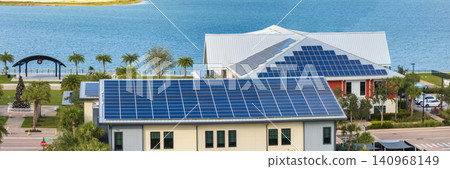 Solar rooftops on commercial center in Florida. Photovoltaic panels for producing of clean ecological electrical energy in city urban area. Concept of autonomous building Solar rooftops on commercial center in Florida. Photovoltaic panels for producing of clean ecological electrical energy in city urban area. Concept of autonomous building 140968149