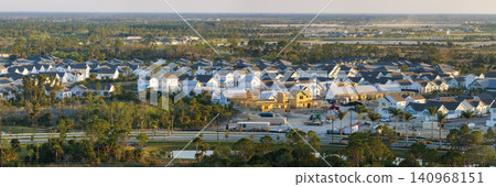 Development of residential housing in the USA. Wooden frames of new cheap American homes under construction Development of residential housing in the USA. Wooden frames of new cheap American homes under construction 140968151